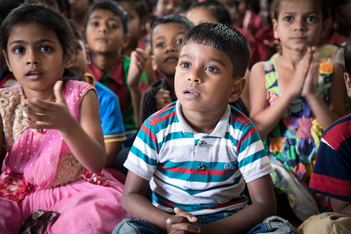 A group of children sitting and listening.