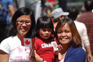 2 women smiling and holding a young girl.