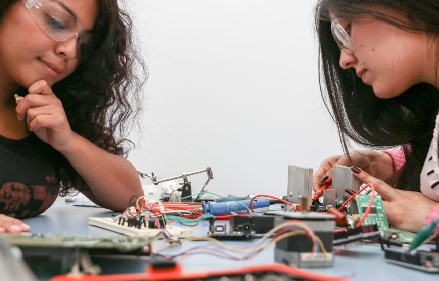 Photo of 2 girls working with technology.