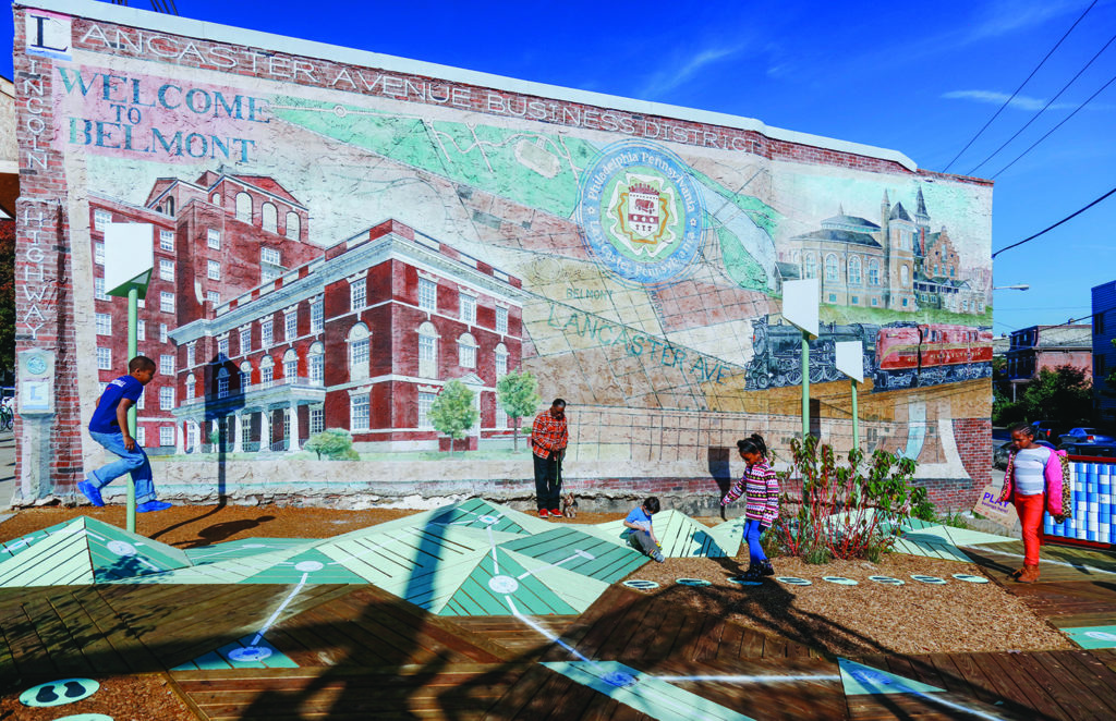 People playing in front of a mosaic in Belmont