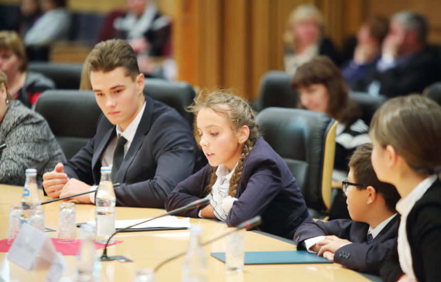 A young girl speaks at a conference