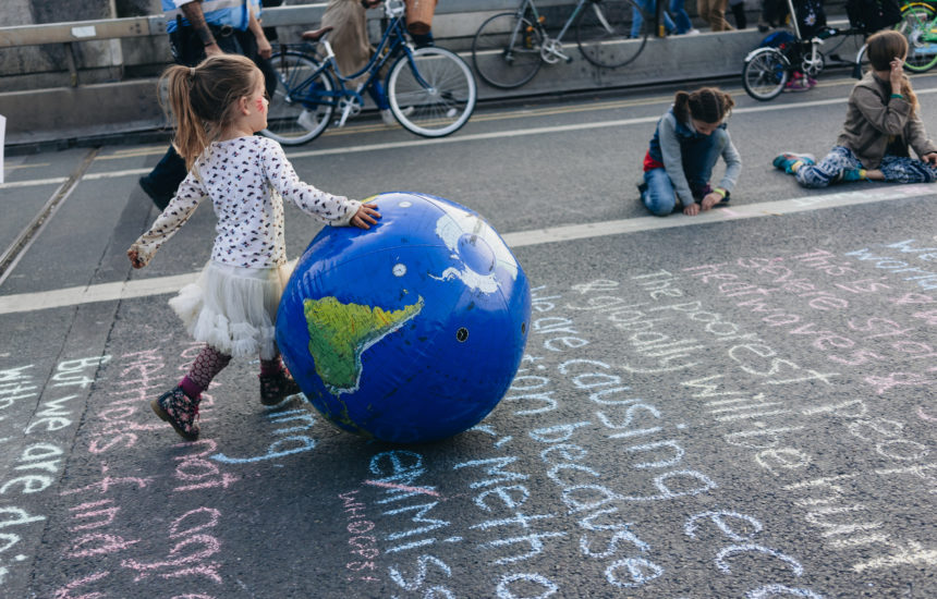 A girl walks with a big inflatable globe