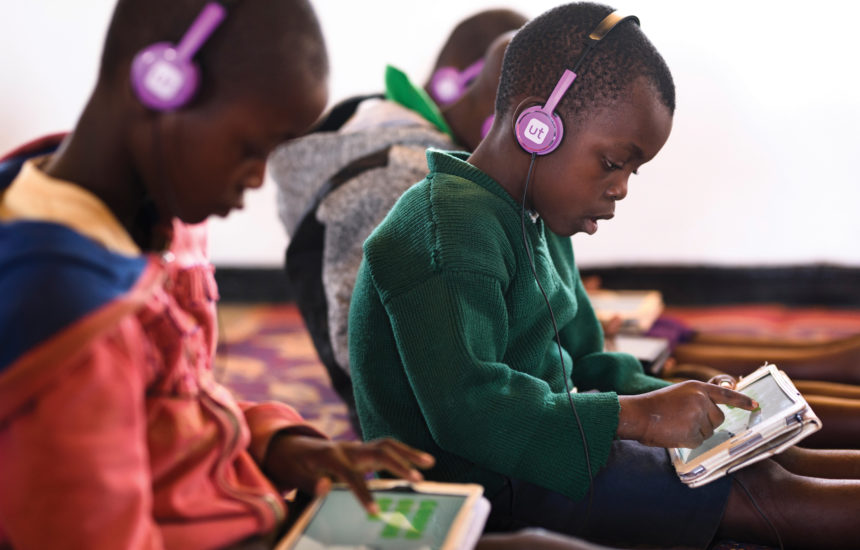 Young boys with headphones on, working on tablets