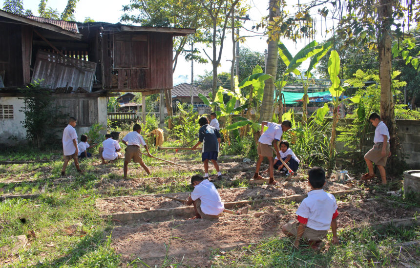 Group of children growing their own garden to mitigate climate change effects through environmental stewardship.