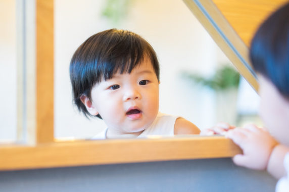 Child looking in mirror.