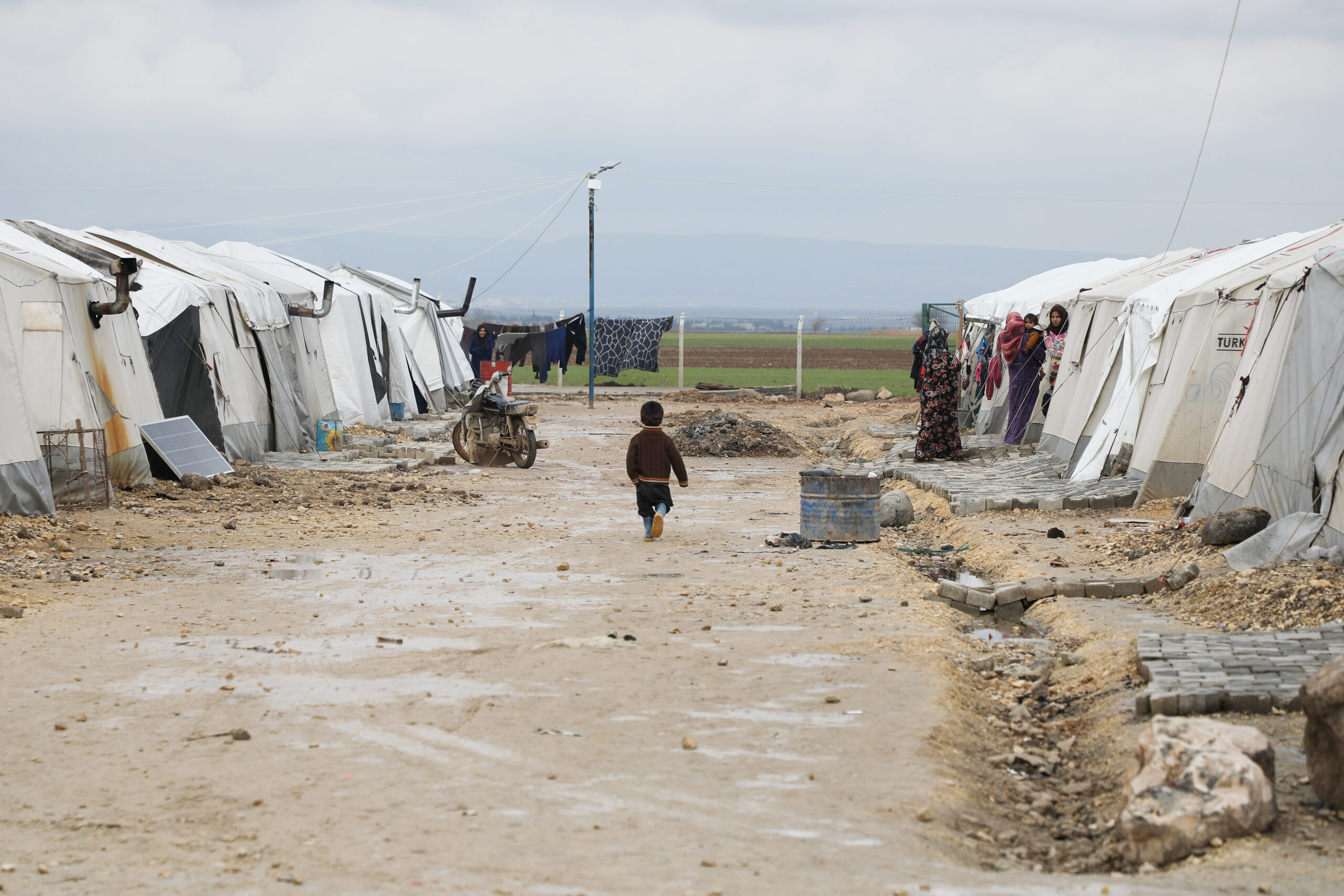 A refugee camp with a child walking through it