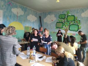 Teachers in a classroom - some standing and some sitting - at a training