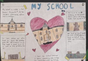 A piece of paper with drawings on it, including a red heart with a drawing of a school inside it in the middle, and "My School" written at the top.