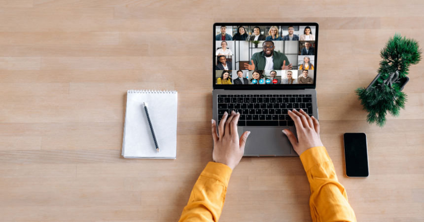 A person working on a laptop, with a Zoom meeting open.