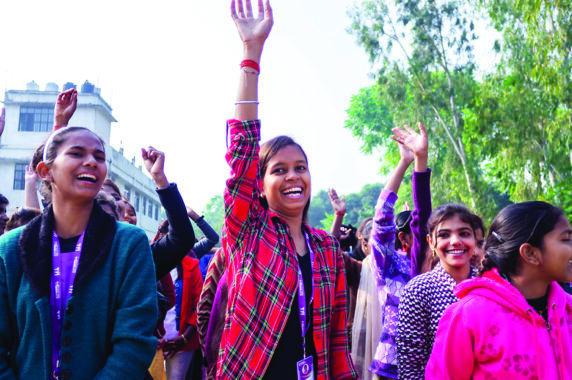 A photo of girls holding their arms in the air.